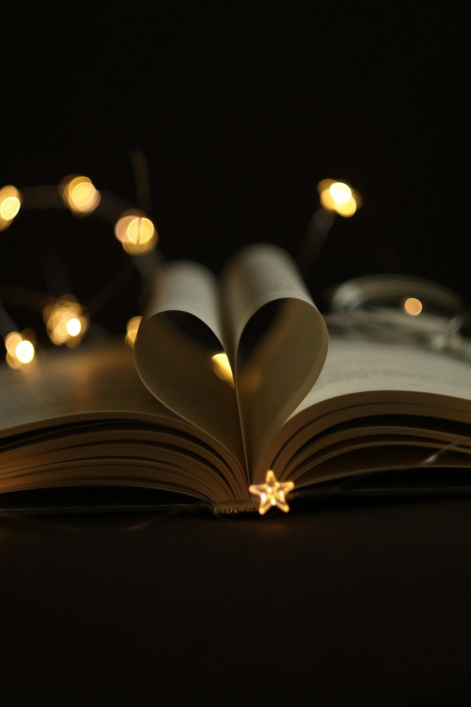 An open book with pages folded into a heart shape.